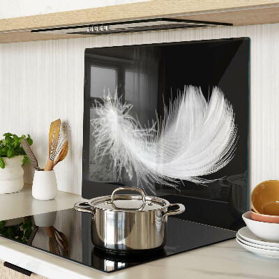Glass kitchen board Feather on black background