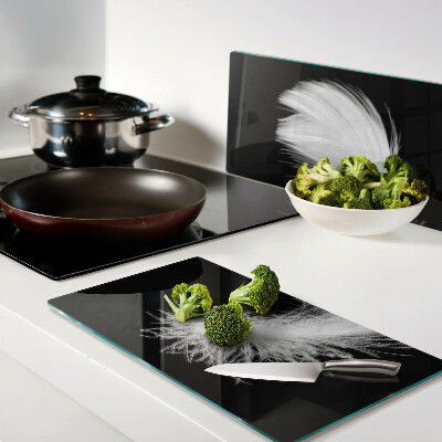 Glass kitchen board Feather on black background