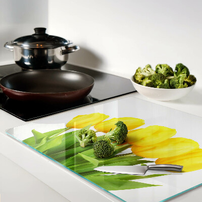 Glass kitchen board Yellow tulips on a green background