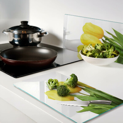 Glass kitchen board Yellow tulips on a green background