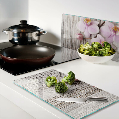 Glass chopping board Orchids on a wood background