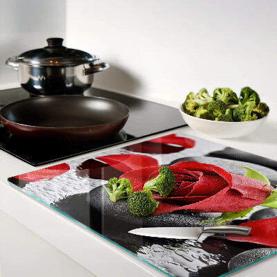 Glass kitchen board Rose on stones with water drops
