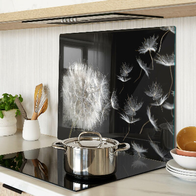 Glass kitchen board Dandelions on a black background