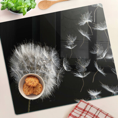 Glass kitchen board Dandelions on a black background