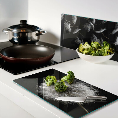 Glass kitchen board Dandelions on a black background