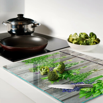 Glass chopping board Dried herbs on a wood background