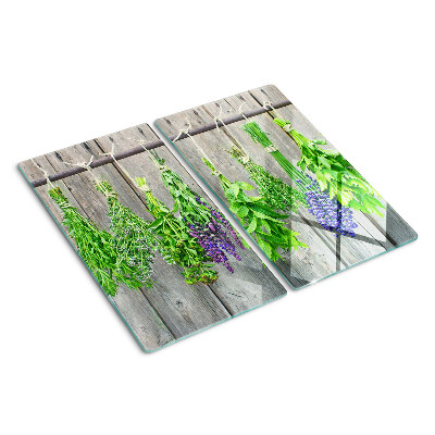 Glass chopping board Dried herbs on a wood background