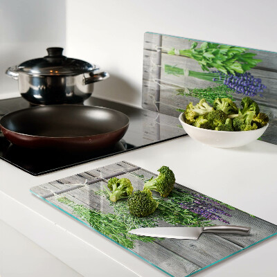 Glass chopping board Dried herbs on a wood background