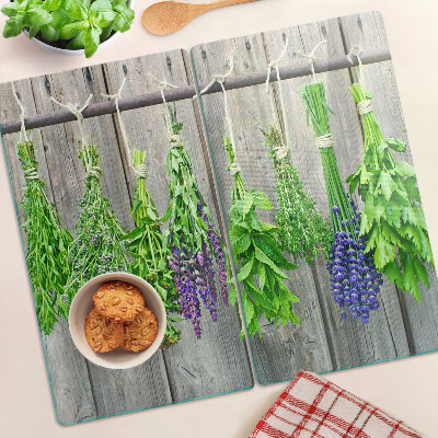 Glass chopping board Dried herbs on a wood background