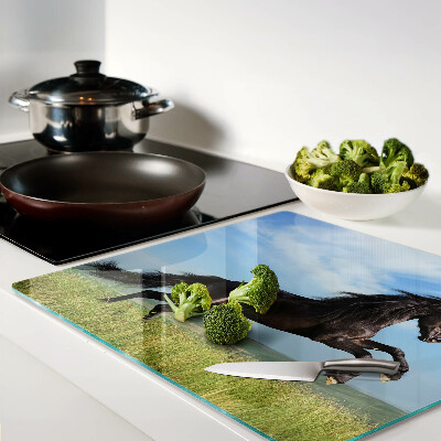 Glass kitchen board Black horse in the meadow