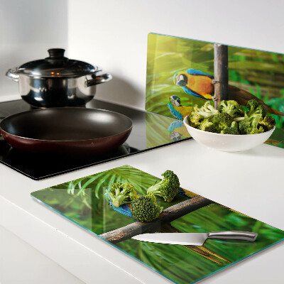 Glass kitchen board Parrots on a branch in the tropics