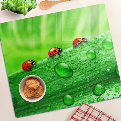 Glass chopping board Ladybugs on a green background