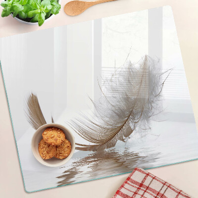 Glass chopping board Feather on the water background