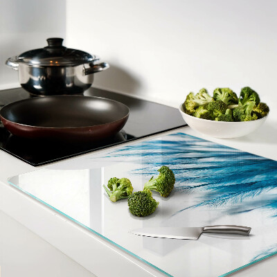 Glass kitchen board Blue feathers on white background