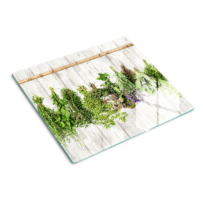Glass chopping board Herbs on a wooden background