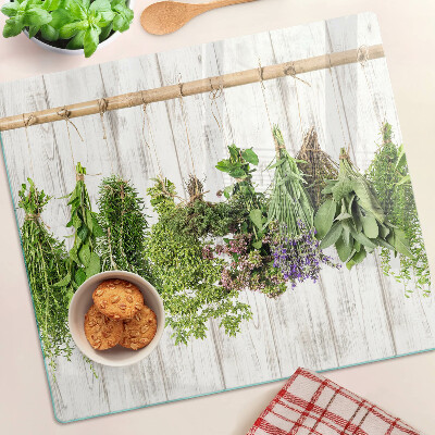 Glass chopping board Herbs on a wooden background