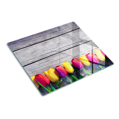 Glass chopping board Tulips on a wooden background