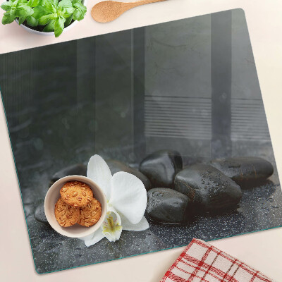 Glass kitchen board Orchid flower on stones
