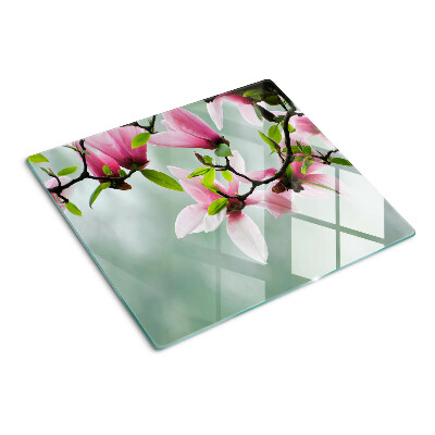 Glass kitchen board Magnolia flowers against a background of greenery