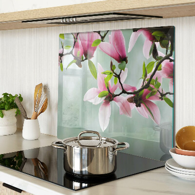 Glass kitchen board Magnolia flowers against a background of greenery