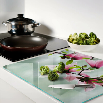 Glass kitchen board Magnolia flowers against a background of greenery