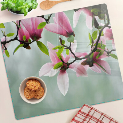 Glass kitchen board Magnolia flowers against a background of greenery