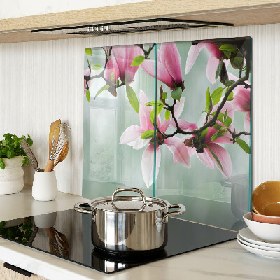 Glass kitchen board Magnolia flowers against a background of greenery