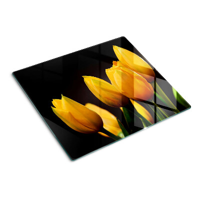 Glass kitchen board Yellow tulips on a black background