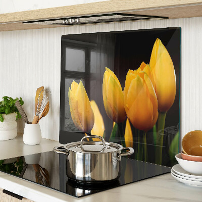 Glass kitchen board Yellow tulips on a black background
