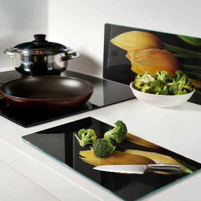 Glass kitchen board Yellow tulips on a black background