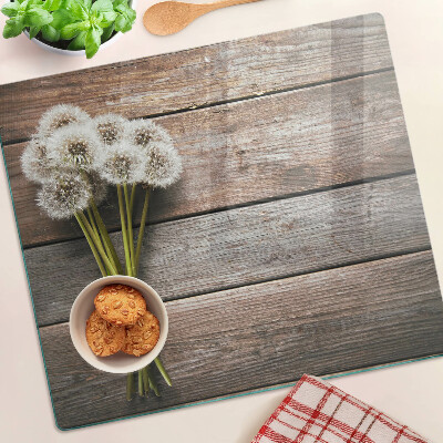 Glass kitchen board Dandelion flowers on a wooden background