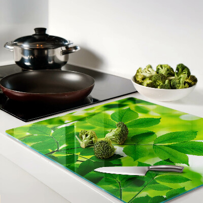 Glass chopping board Leaves on a green background