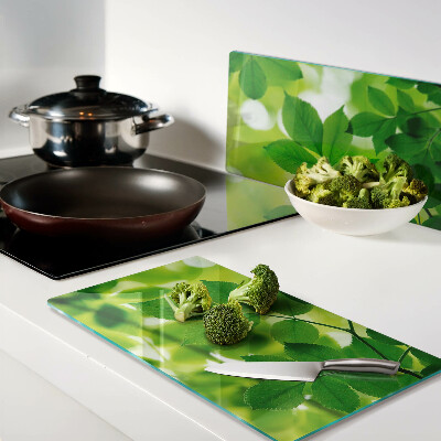 Glass chopping board Leaves on a green background