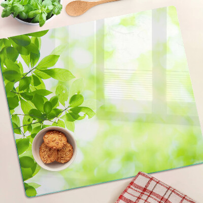 Glass chopping board Green leaves in the light