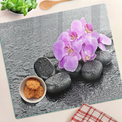 Glass chopping board Flowers and stones against the water