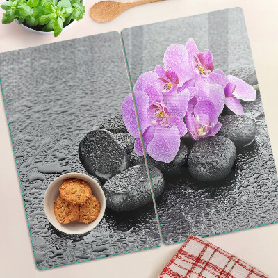 Glass chopping board Flowers and stones against the water