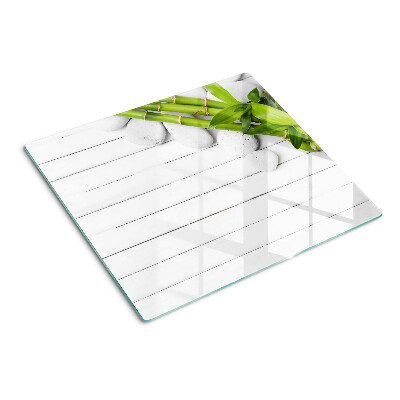 Glass kitchen board Bamboo and stones on a wood background