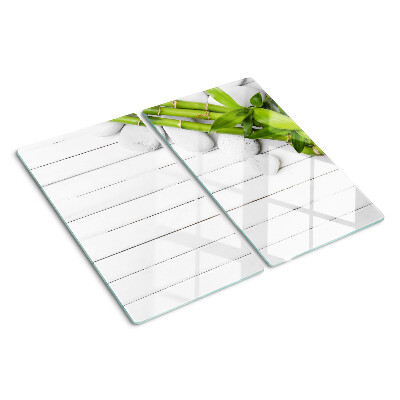 Glass kitchen board Bamboo and stones on a wood background