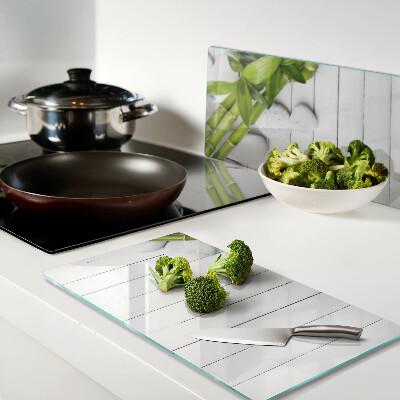 Glass kitchen board Bamboo and stones on a wood background