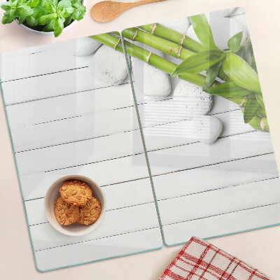 Glass kitchen board Bamboo and stones on a wood background