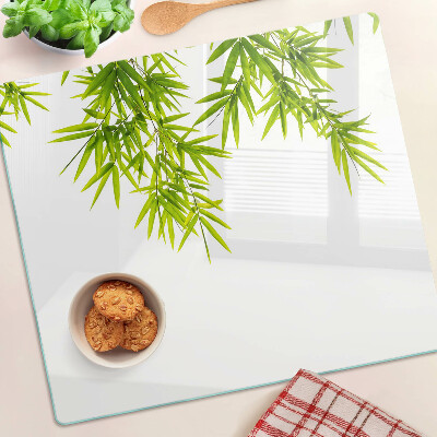 Glass chopping board Bamboo leaves on the window background