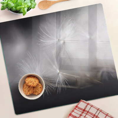 Glass kitchen board Fluffy dandelions against the window background