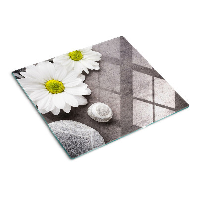 Glass chopping board Flowers and stones on the background