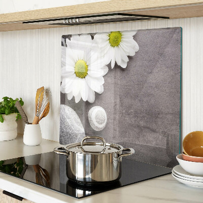 Glass chopping board Flowers and stones on the background