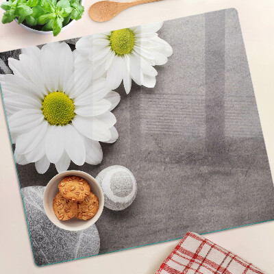 Glass chopping board Flowers and stones on the background