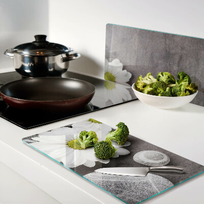 Glass chopping board Flowers and stones on the background