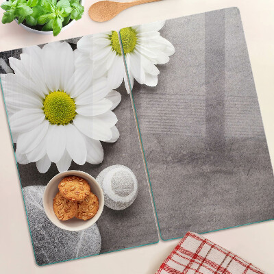 Glass chopping board Flowers and stones on the background