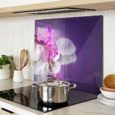 Glass chopping board Orchid flowers on a background of stones