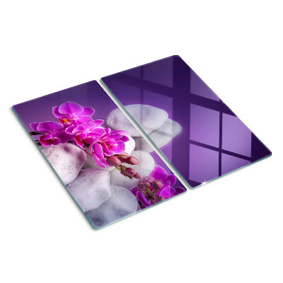 Glass chopping board Orchid flowers on a background of stones
