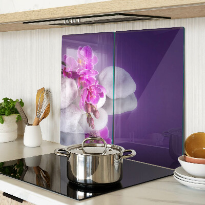 Glass chopping board Orchid flowers on a background of stones